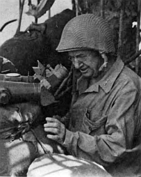 LtGen Holland M. Smith observes his troops from his command post ashore on Saipan